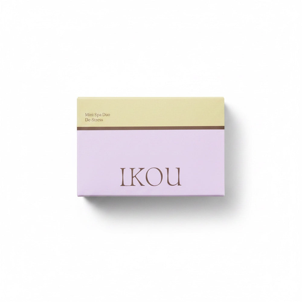 Two skincare products from the brand iKOU on a clean white background: a clear jar of Organic Body Buff in orange and jojoba oil, and a white jar of De-Stress Organic Body Crème.