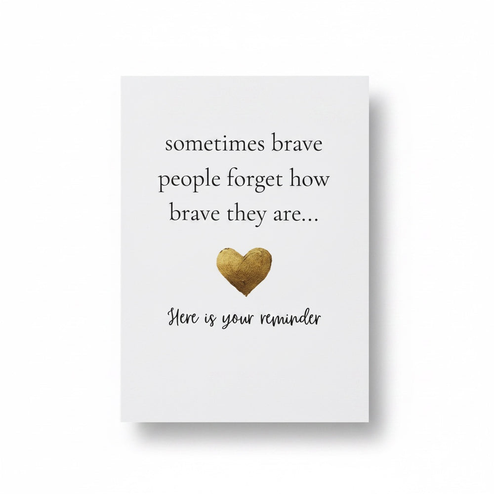 A white rectangular card with printed black text reading 'sometimes brave people forget how brave they are.
