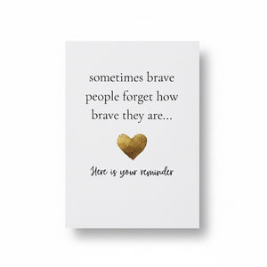 A white rectangular card with printed black text reading 'sometimes brave people forget how brave they are.