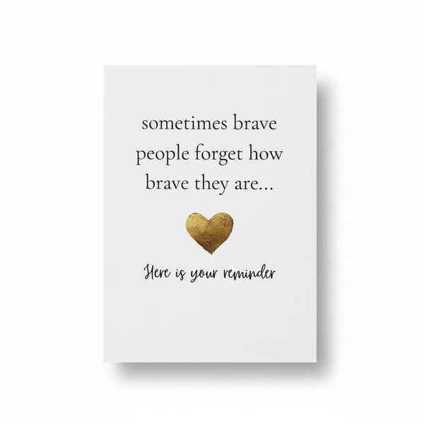 A white rectangular card with printed black text reading 'sometimes brave people forget how brave they are.